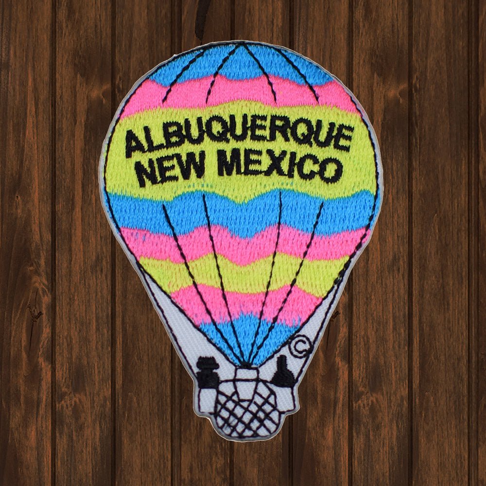 Colorful embroidered hot air balloon patch with 'Albuquerque New Mexico' text, featuring bright stripes in blue, pink, and yellow. Perfect for sewing or ironing on jackets, backpacks, and other clothing.